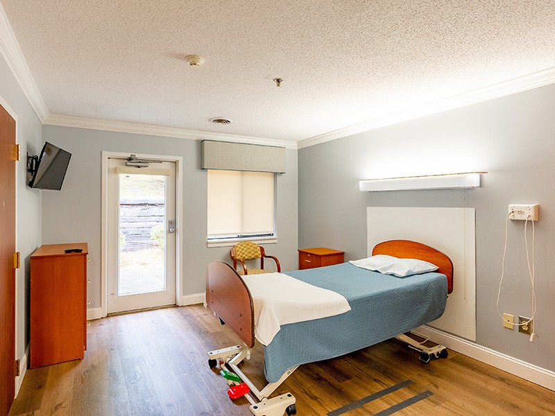 A clean and modern hospital room with a bed and basic amenities.