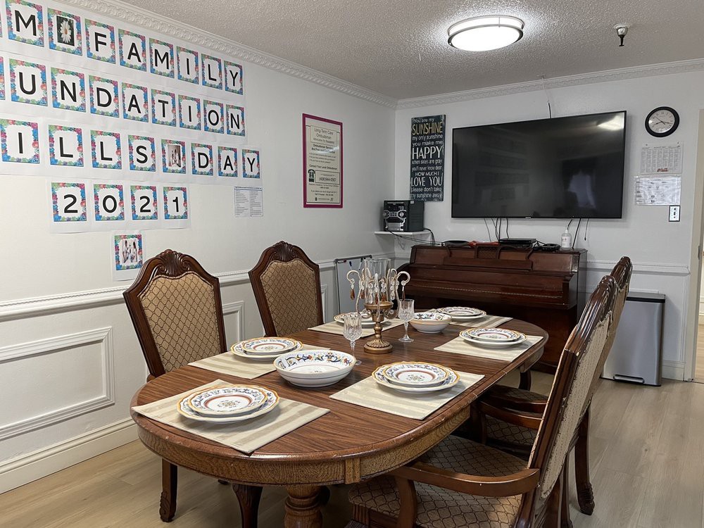 A well-decorated dining room with a table set for a meal, featuring elegant chairs and wall art.