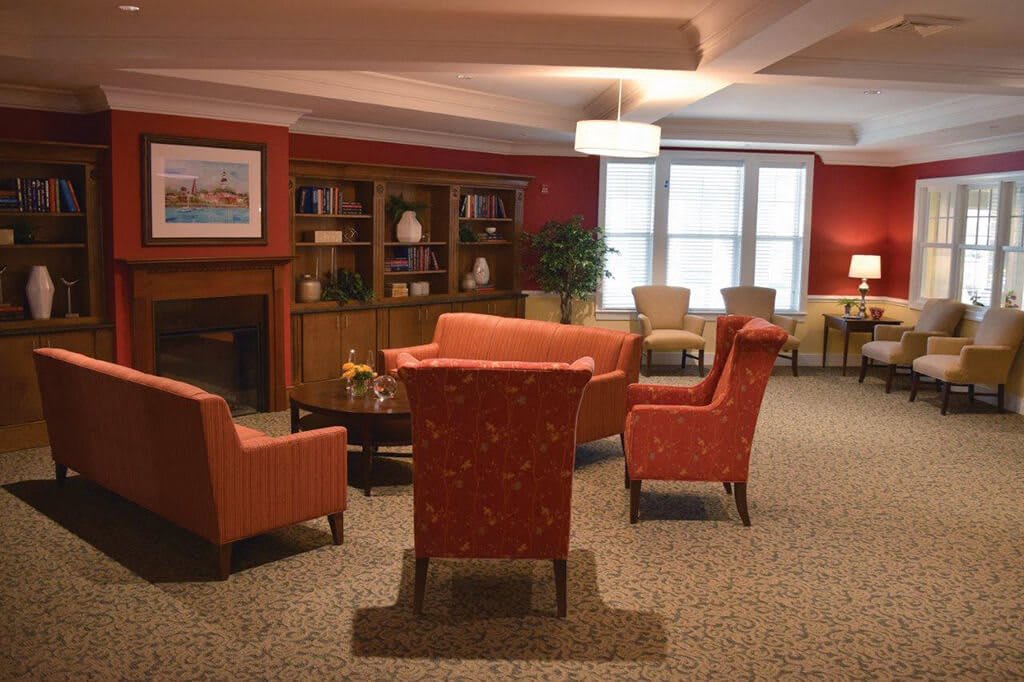 A cozy living room featuring comfortable seating, a fireplace, and a bookshelf.