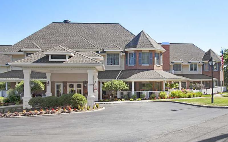 A large residential building with a landscaped front area.
