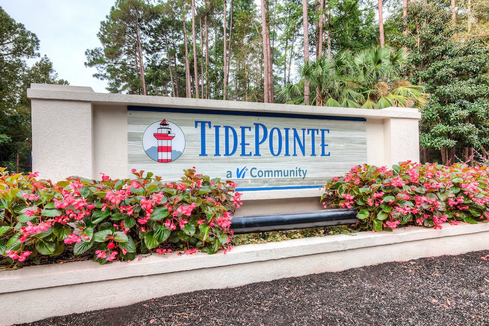 Entrance sign for TidePointe community surrounded by flowers and trees.