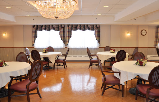 An elegant dining room setup featuring round tables and a chandelier.