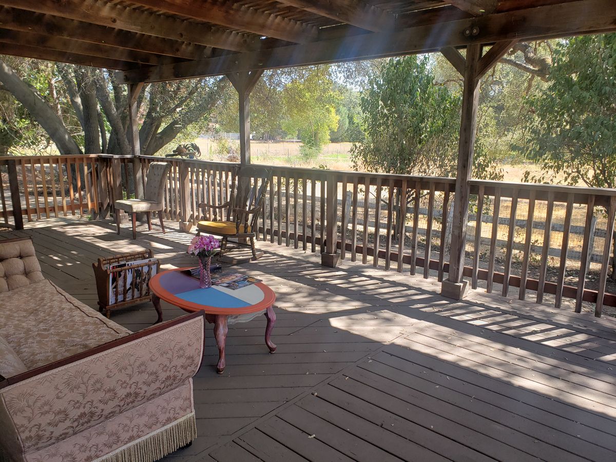 A rustic wooden porch with comfortable seating, ideal for relaxation.