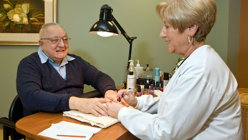 A joyful moment during a manicure session, showcasing the caring interaction between a nail technician and her client.