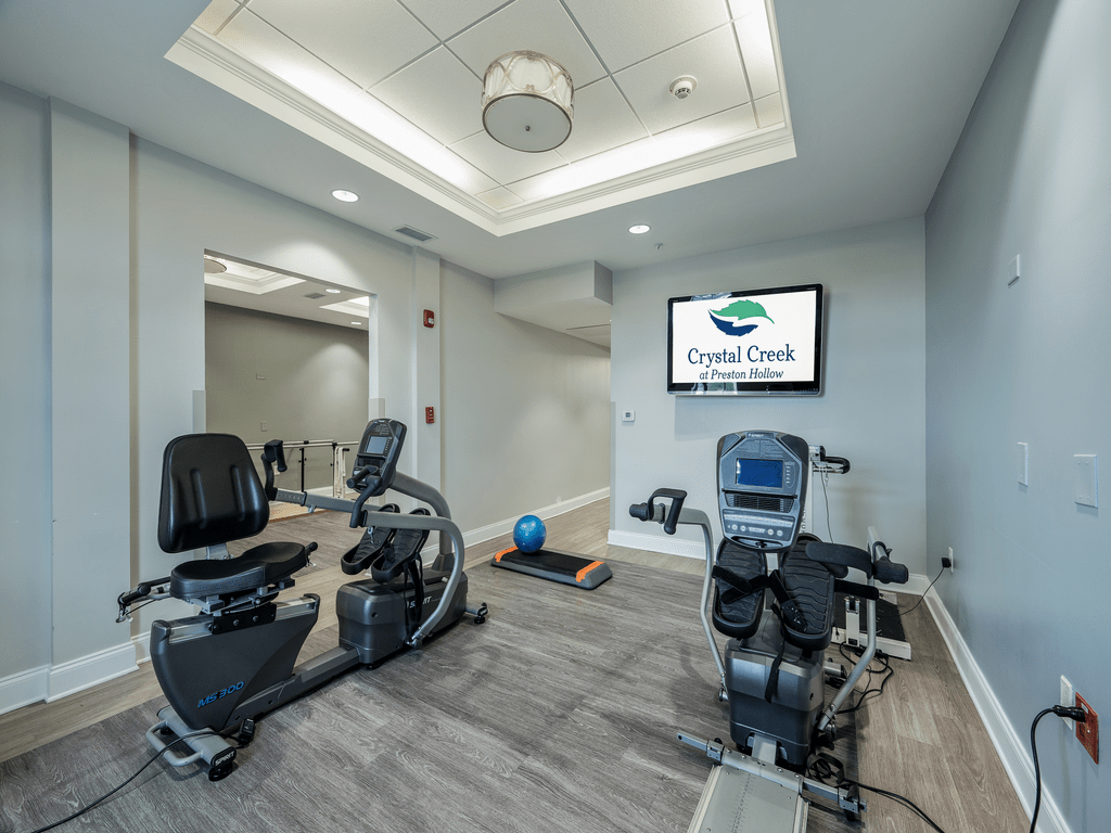 A modern fitness room equipped with stationary bikes and a treadmill.