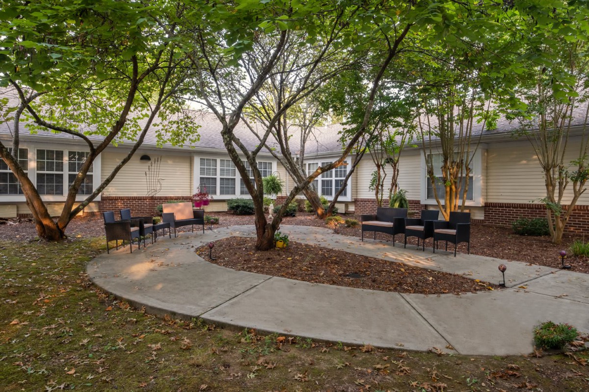 A peaceful courtyard with trees, benches, and a winding pathway.