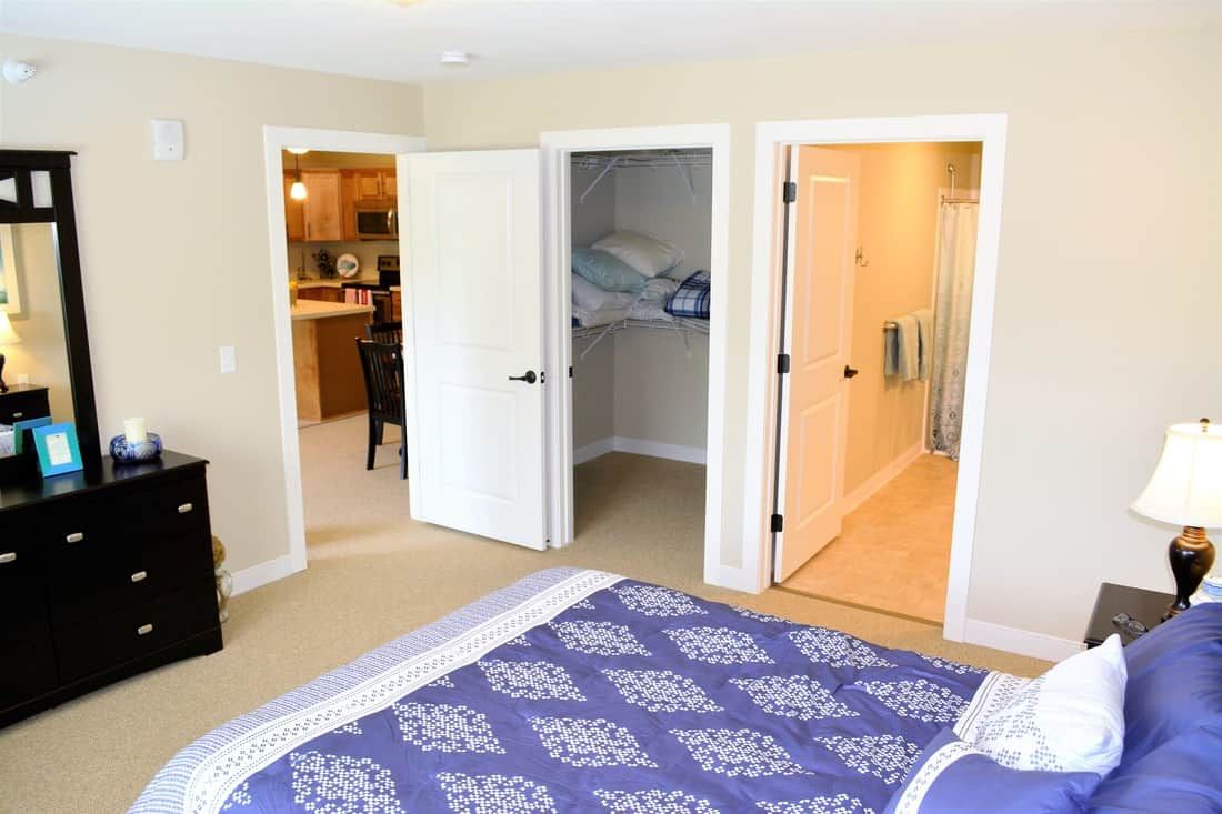 A cozy bedroom with an open closet and adjacent bathroom.