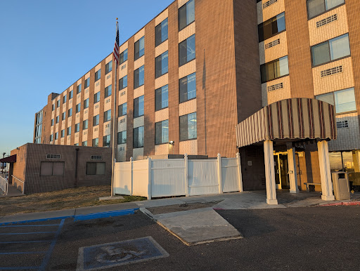 A view of a brick hotel building featuring multiple windows and handicap accessible entrance.