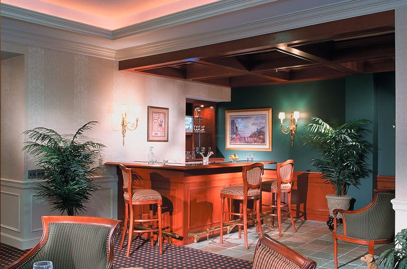 An elegant bar area with high stools and warm lighting.