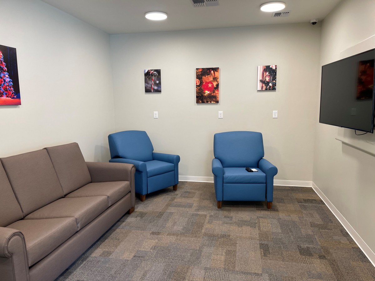 A waiting room with comfortable seating and colorful artwork on the walls.