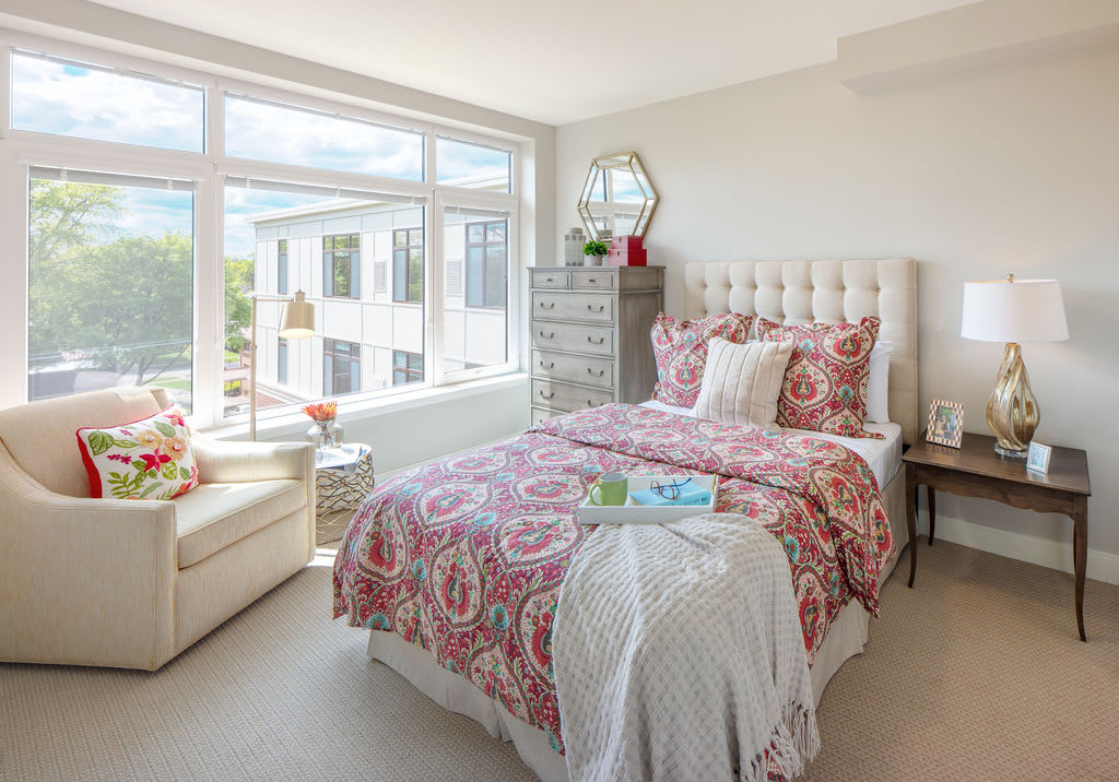 A bright and cozy bedroom with modern decor and a large window.