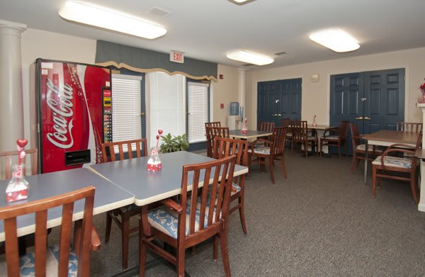 A community room with tables and chairs arranged for meetings or gatherings.
