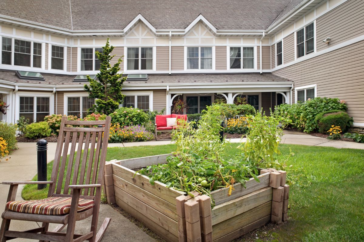 A peaceful courtyard with a raised garden bed and rocking chair.