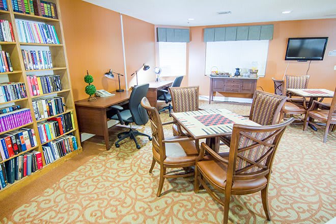A well-organized office space with desks, chairs, and a bookshelf.
