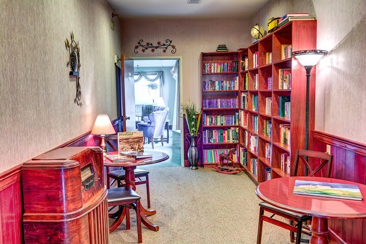 A cozy library corner with bookshelves and a reading table.