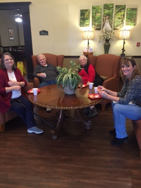 A group of people sitting around a table enjoying coffee indoors.