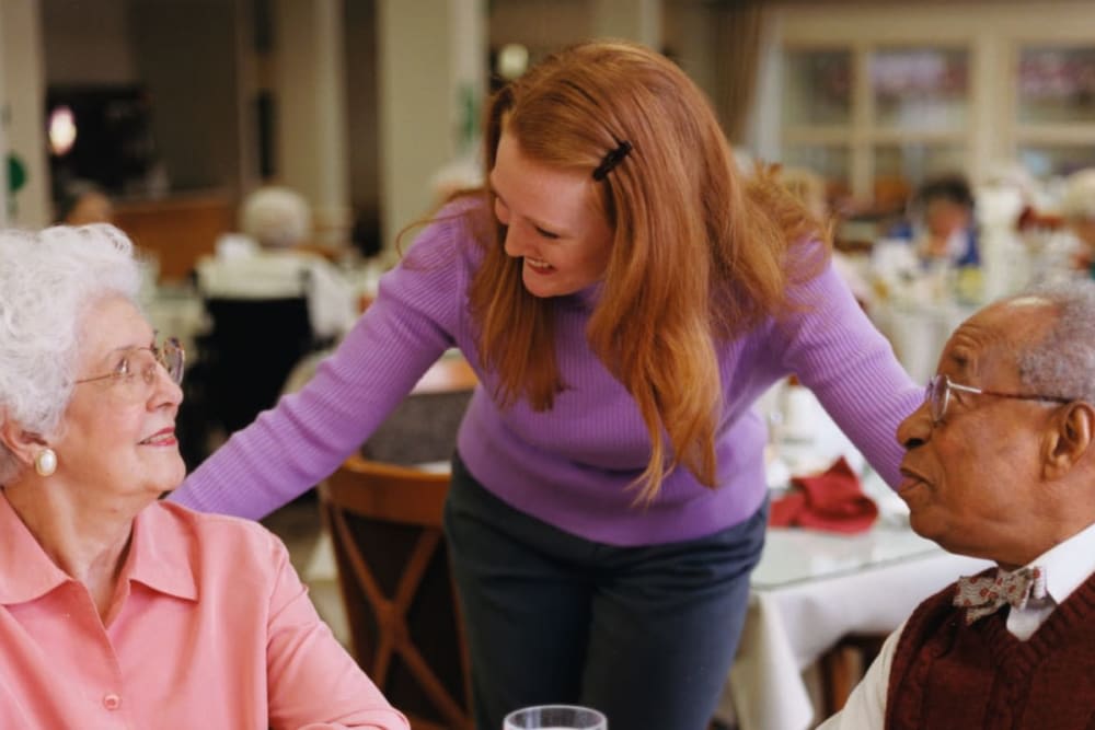 A woman engaging in conversation at a dining table indoors.