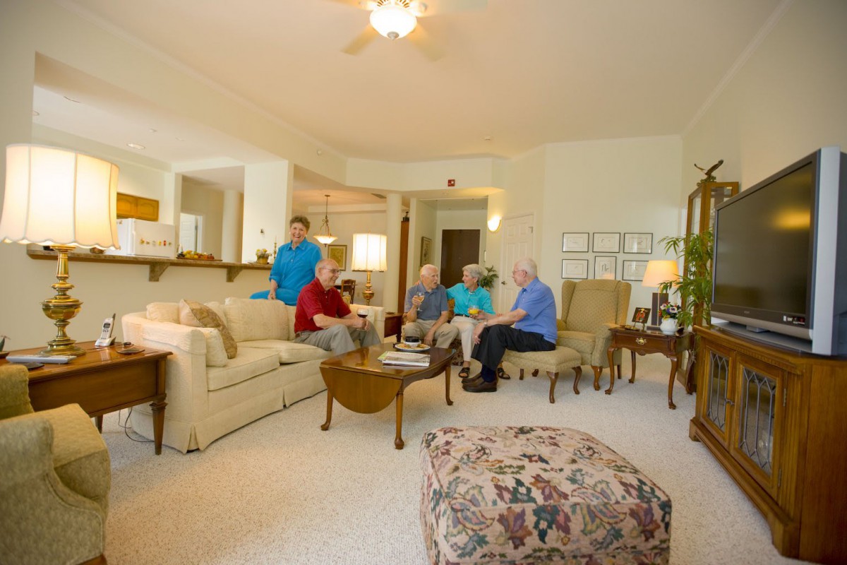 A group of seniors gathered in a cozy living room for a conversation.