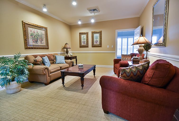 A cozy living room with comfortable sofas, elegant artwork on the walls, and a warm atmosphere.
