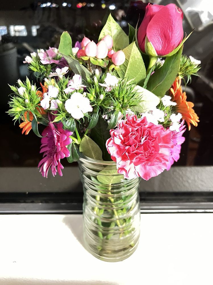 A vibrant bouquet of assorted flowers in a glass vase.