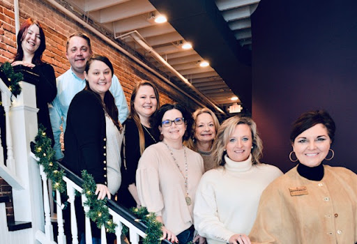 A cheerful gathering of friends on the stairs, sharing smiles in a cozy indoor setting.