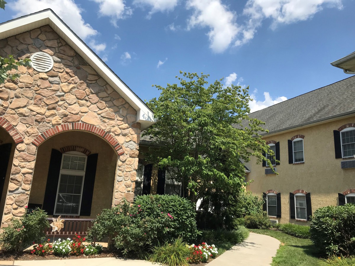 A beautiful residential house with a well-maintained garden and a clear blue sky.