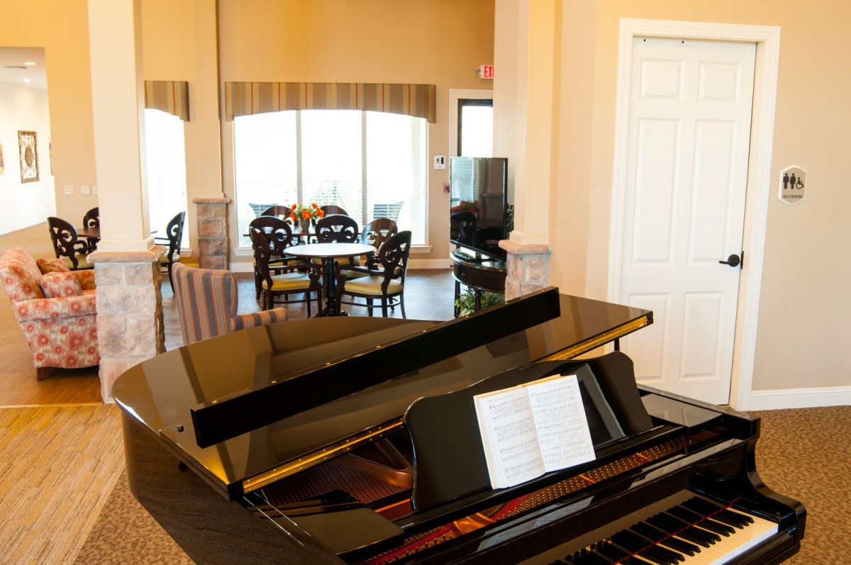 A grand piano in a cozy living room setting with elegant furniture.
