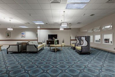 A spacious waiting room with modern furnishings and a patterned carpet.