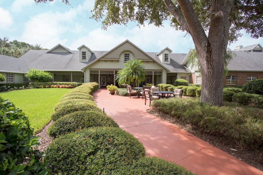 A charming house with a well-maintained lawn and outdoor seating area.