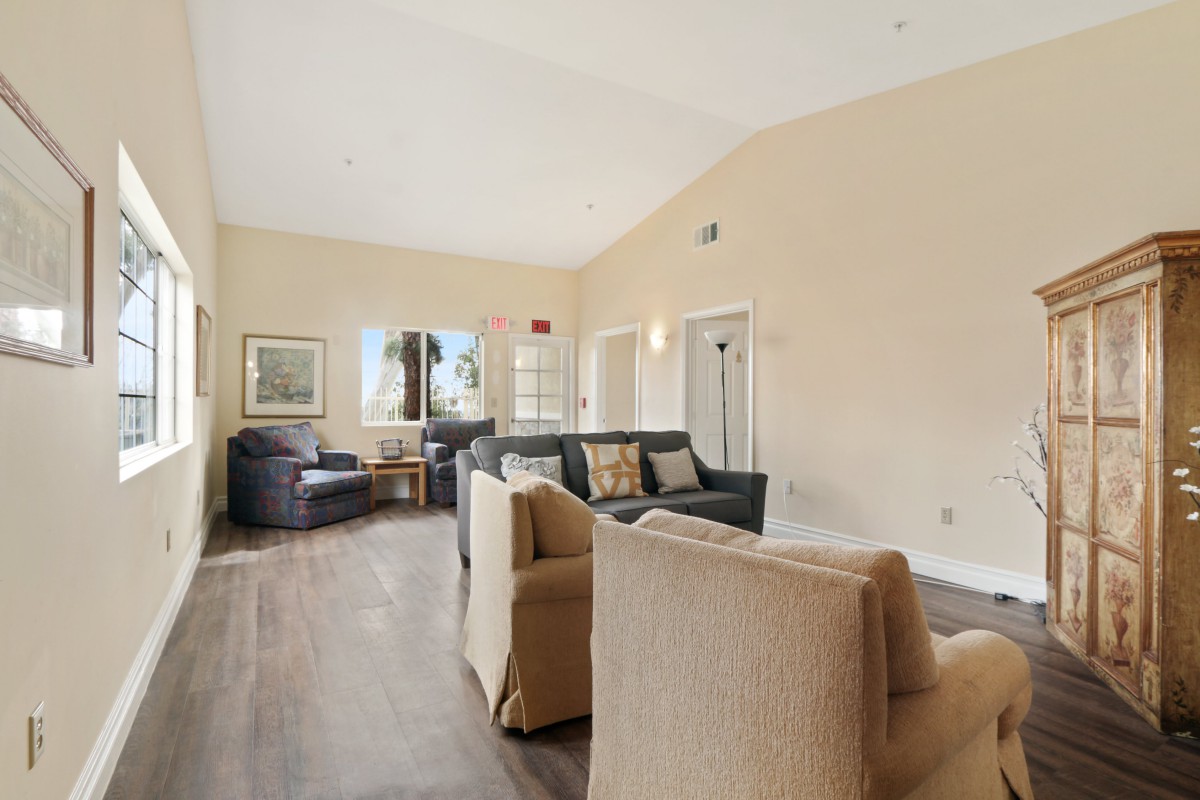 A spacious living room with a lofted ceiling, featuring comfortable seating and ample natural light.