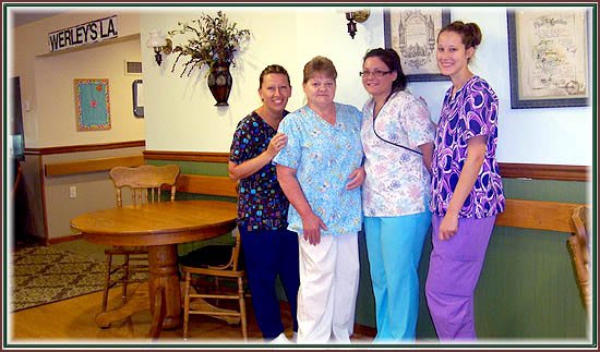 A group of nurses in scrubs posing together indoors.