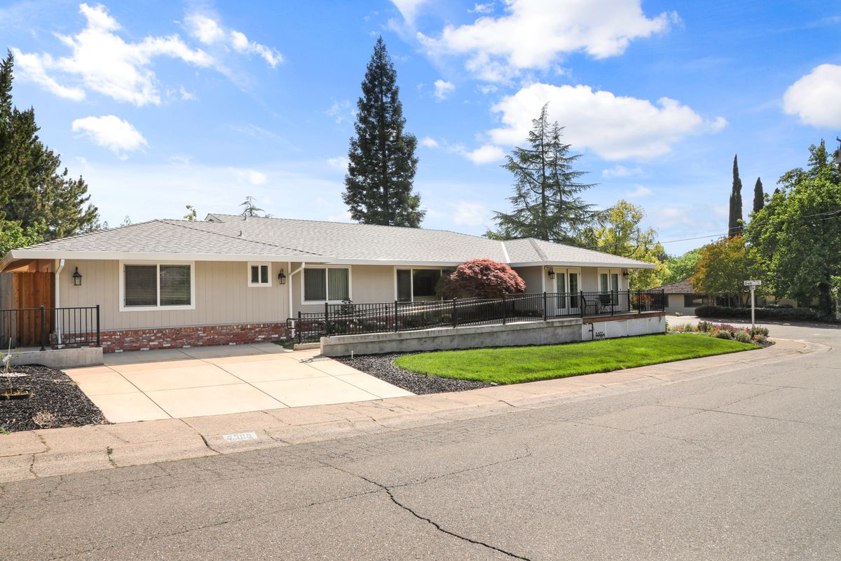 A suburban single-story house with a well-maintained yard and driveway.