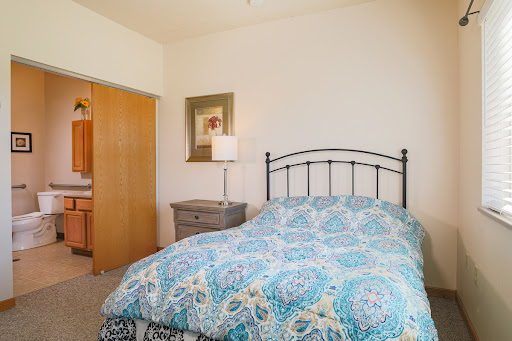A cozy bedroom featuring a patterned bedspread and charming decor.