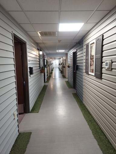 A long indoor hallway with multiple doors and a well-lit ceiling.