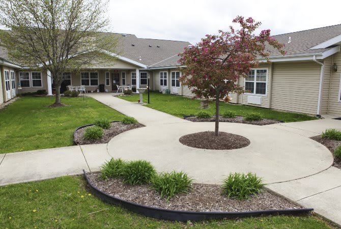 A residential building with a landscaped garden and sidewalk.