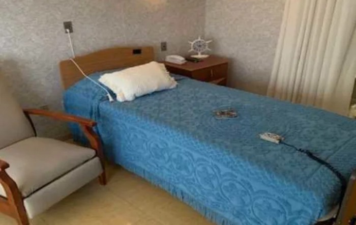 A hospital room with a bed and bedside table.