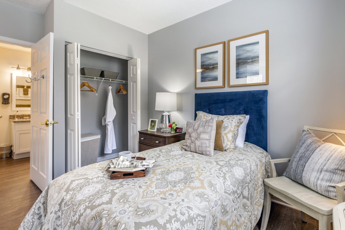 A cozy bedroom with a blue headboard, patterned bedding, and decorative elements.