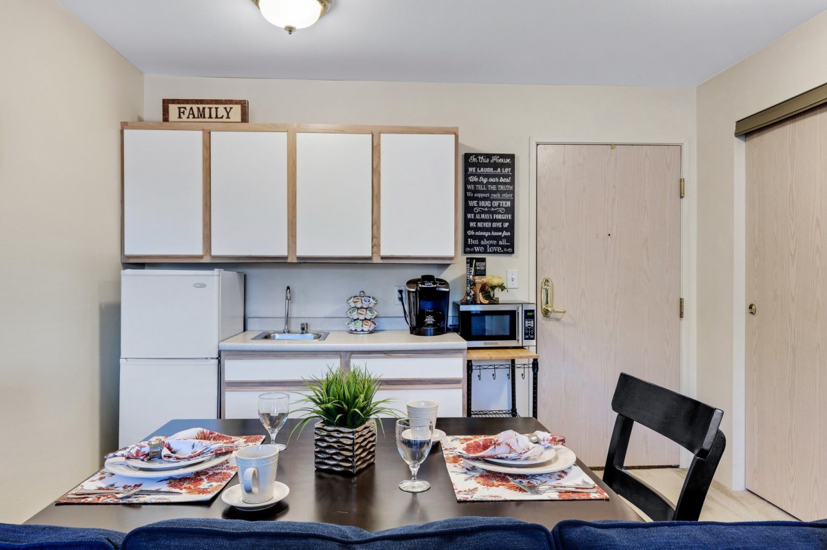A modern kitchen with a neatly set dining table featuring contemporary appliances and dcor.