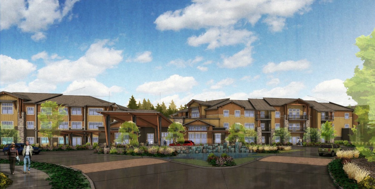 A modern apartment complex surrounded by trees and a clear sky.