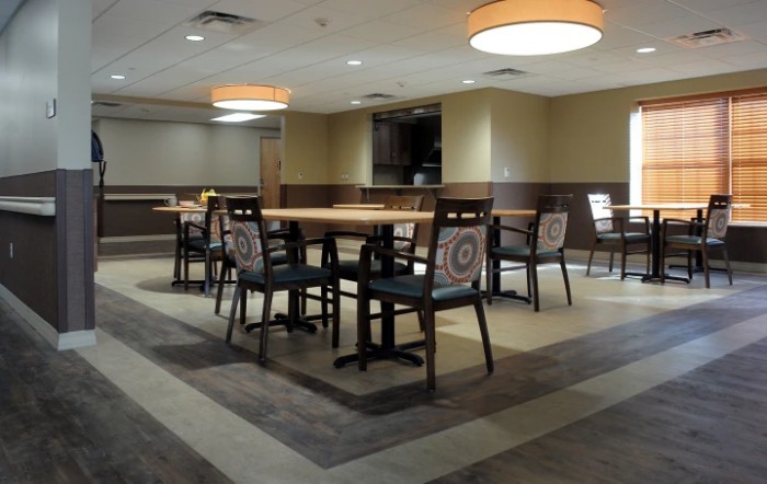 An empty dining area with neatly arranged tables and chairs under soft lighting.