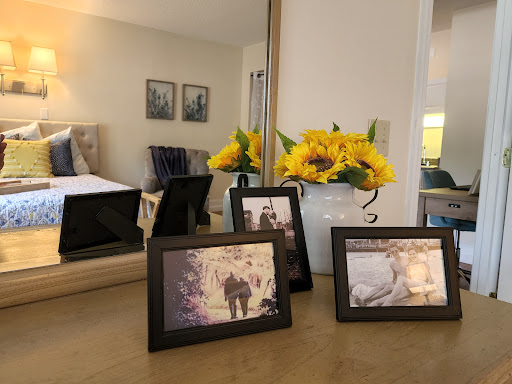 A cozy living room setup featuring photo frames and fresh sunflowers on a table.