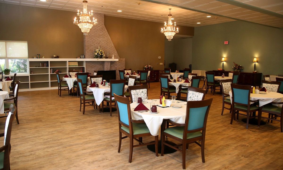 An elegant indoor dining room with neatly arranged tables and chandeliers.