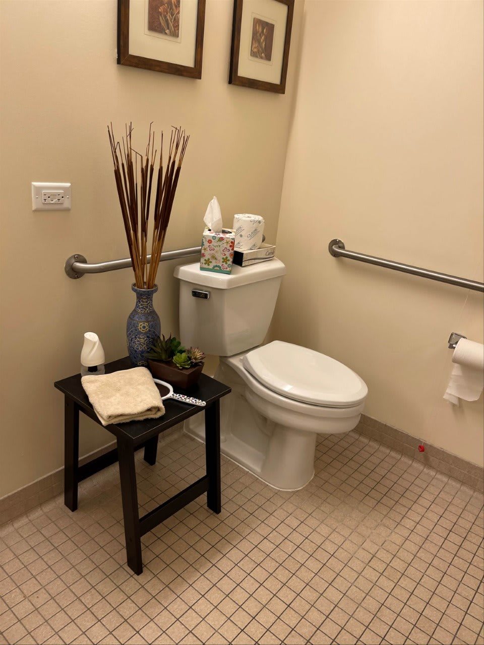 A well-decorated bathroom with a toilet, side table, and decorative items.