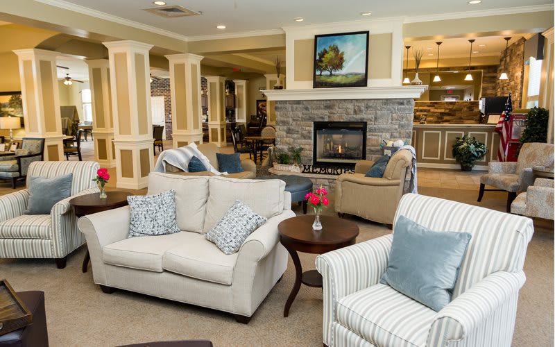 A cozy, well-decorated living room with comfortable seating and a stone fireplace.