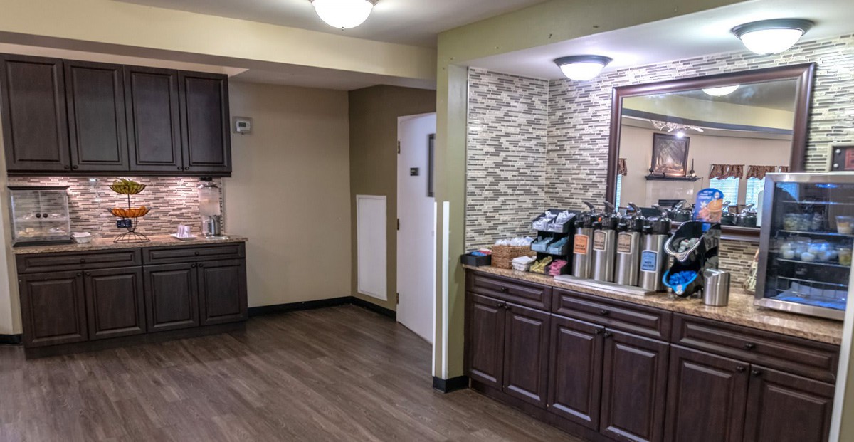 A modern indoor coffee station with stylish cabinetry and beverage options.