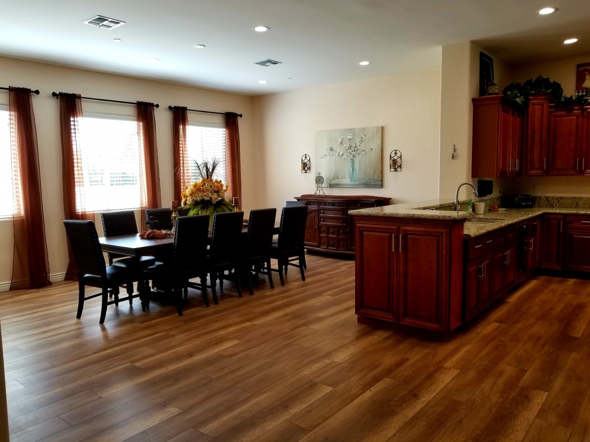 A spacious kitchen and dining area with wooden flooring and elegant furniture.