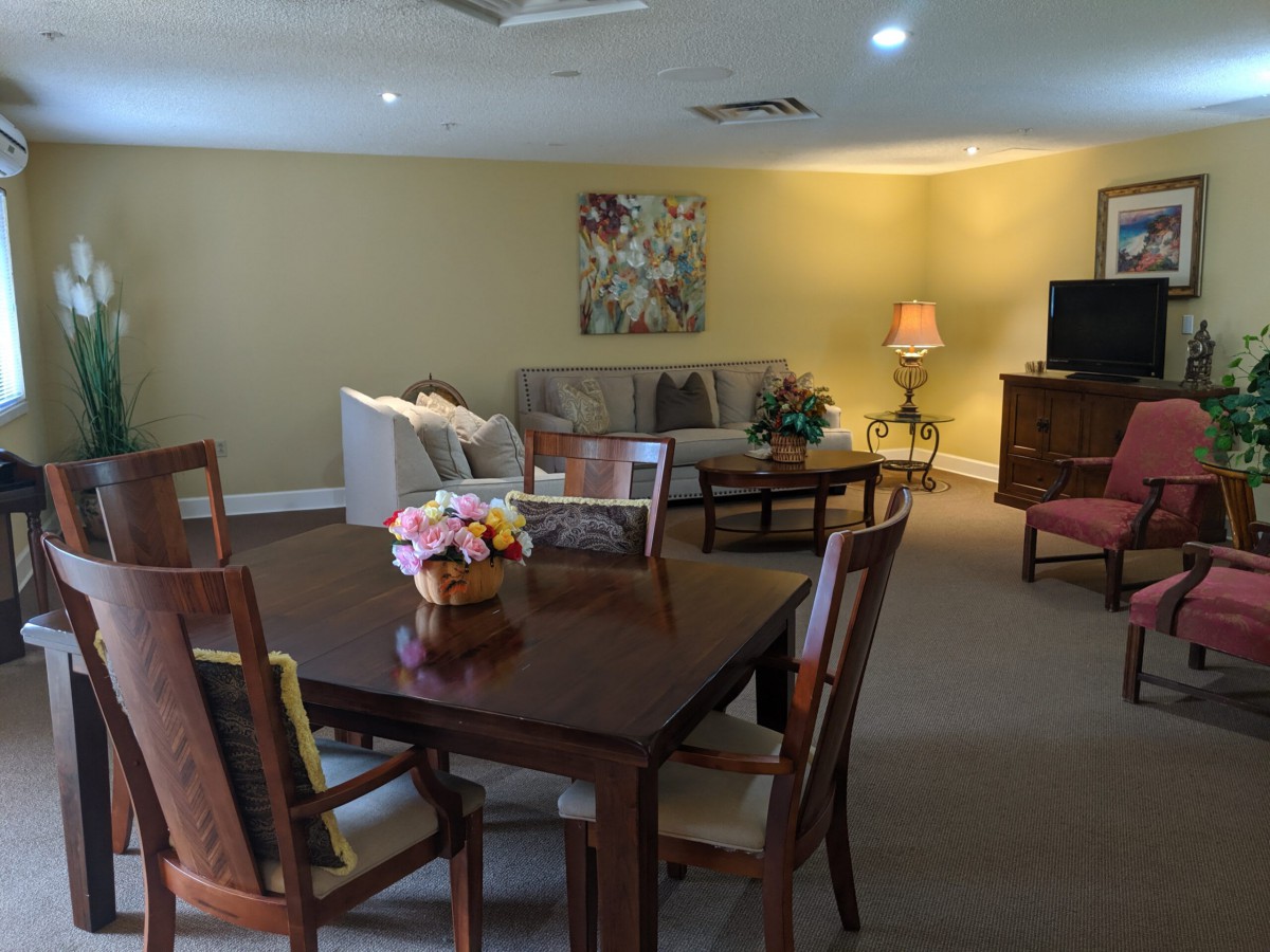 A cozy living room with a dining table, comfortable sofa, and a television setup.