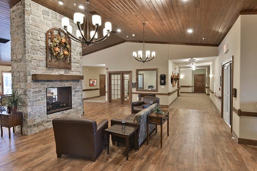 A cozy lobby with a fireplace, seating area, and elegant chandeliers.