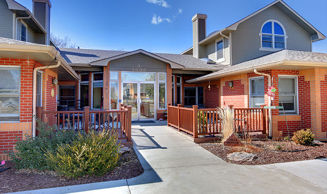 A residential building with a pathway leading up to the entrance on a clear day.