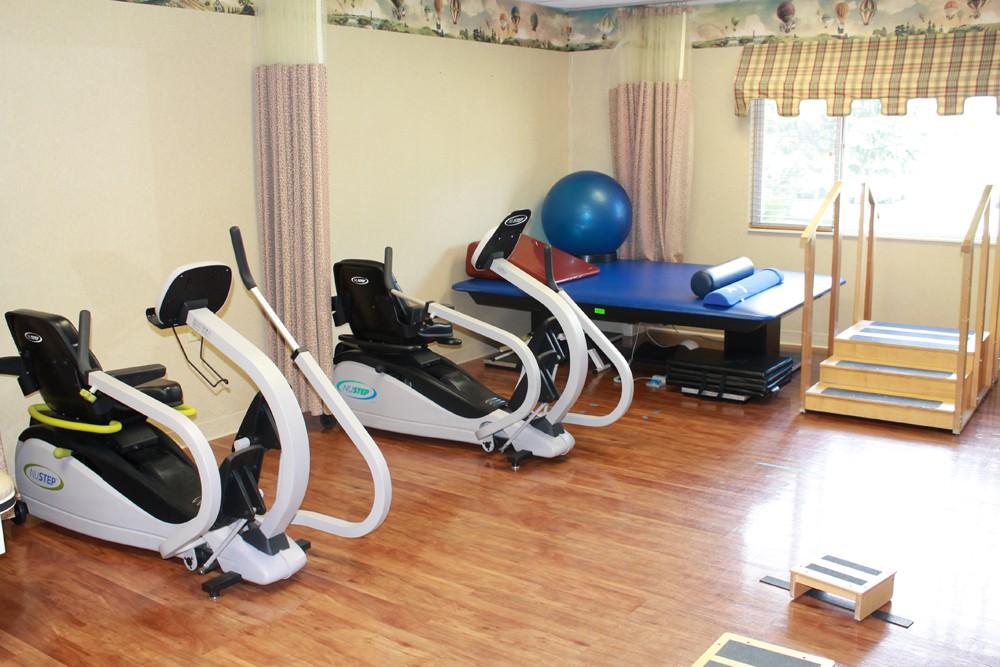 A physical therapy room equipped with recumbent bikes and exercise equipment.